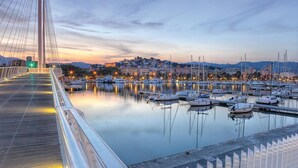 A bridge with a view of a marina and cityscape in the background.