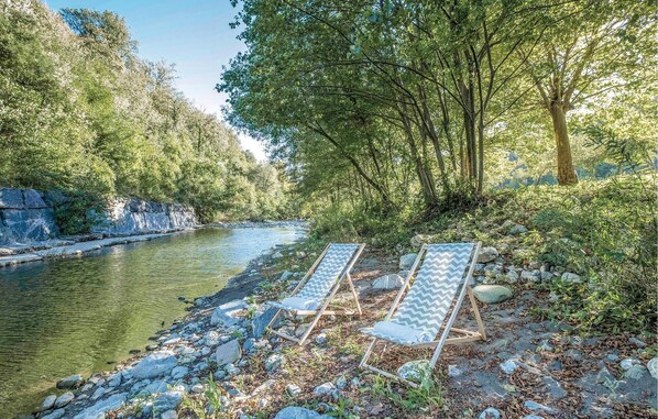 A riverside setting with two wooden lounge chairs and a rocky riverbank. - Pet friendly home in Varese Ligure SP (Varese Ligure SP)