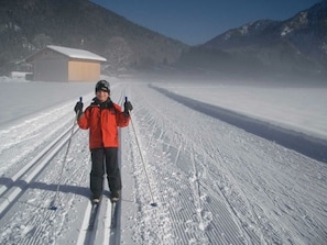 A person skiing on a snowy path with a building in the background. - Superior Double Room - Bio Design Boutique Hotel Landhaus St. Georg (Bad Wiessee)