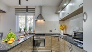 Una cocina moderna con horno empotrado, una isla grande con productos frescos y una encimera elegante.