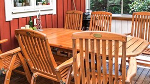 Een houten eettafel omringd door zes stoelen, met een raam op de achtergrond.