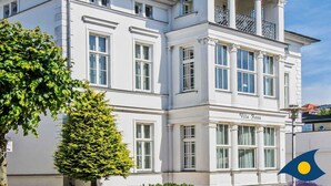 Ein weißes Gebäude mit Balkon und dem Schriftzug "Villa Anna" an der Fassade.