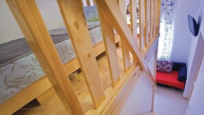 A wooden staircase leading to a lower level with a red sofa and patterned cushions. - Awesome apartment in Pula with WiFi (Pula)