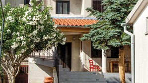 A building with a tiled roof, a staircase leading to the entrance, and a red chair outside. - Awesome apartment in Pula with WiFi (Pula)