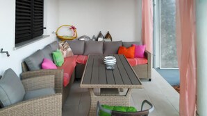 A cozy living area with a sofa set, a dining table, and a wicker chair. - Awesome apartment in Pula with WiFi (Pula)
