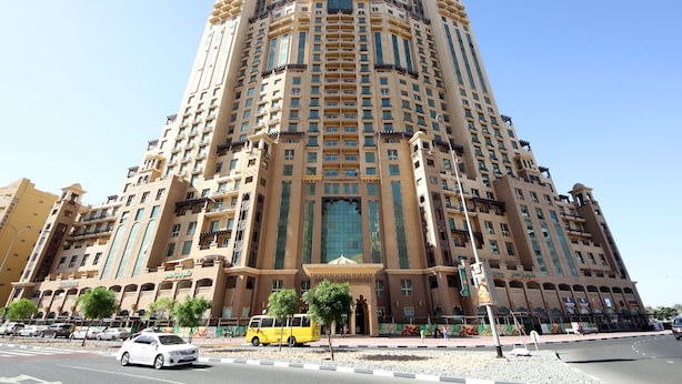 Un grand hôtel à plusieurs étages, doté d’une entrée centrale et de balcons.
