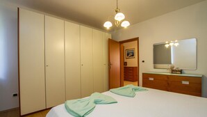 A bedroom with a bed, a dresser, a mirror, and a wardrobe. - Nice home in Nedescina (Nedescina)