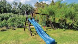 A playground with a blue slide and a swing set. - Nice home in Nedescina (Nedescina)