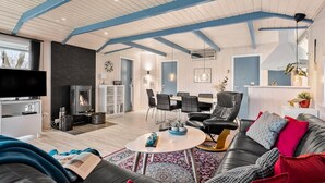 Un salon moderne avec une cheminée, un coin repas et un canapé.