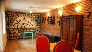 A dining area with a brick wall, stone accents, and a wooden cabinet.