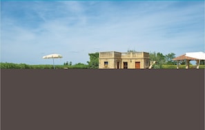 A stone building with a balcony, a white umbrella, and a gazebo. - Nice apartment in Pomarance PI with WiFi (Pomarance PI)