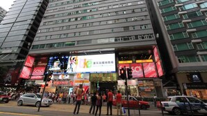 A multi-story commercial building with a large billboard advertising a shopping mall.