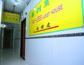 A hallway with a sign indicating a pay-less guest house.