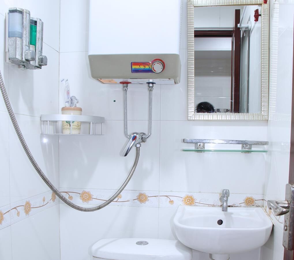 Ein Badezimmer mit Dusche, Waschbecken und Spiegel.