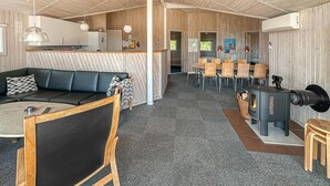 Un intérieur moderne comprenant un canapé, un coin repas et un poêle à bois.