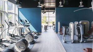 Ein Fitnessstudio mit Cardiogeräten, Kraftstationen und Bänken.