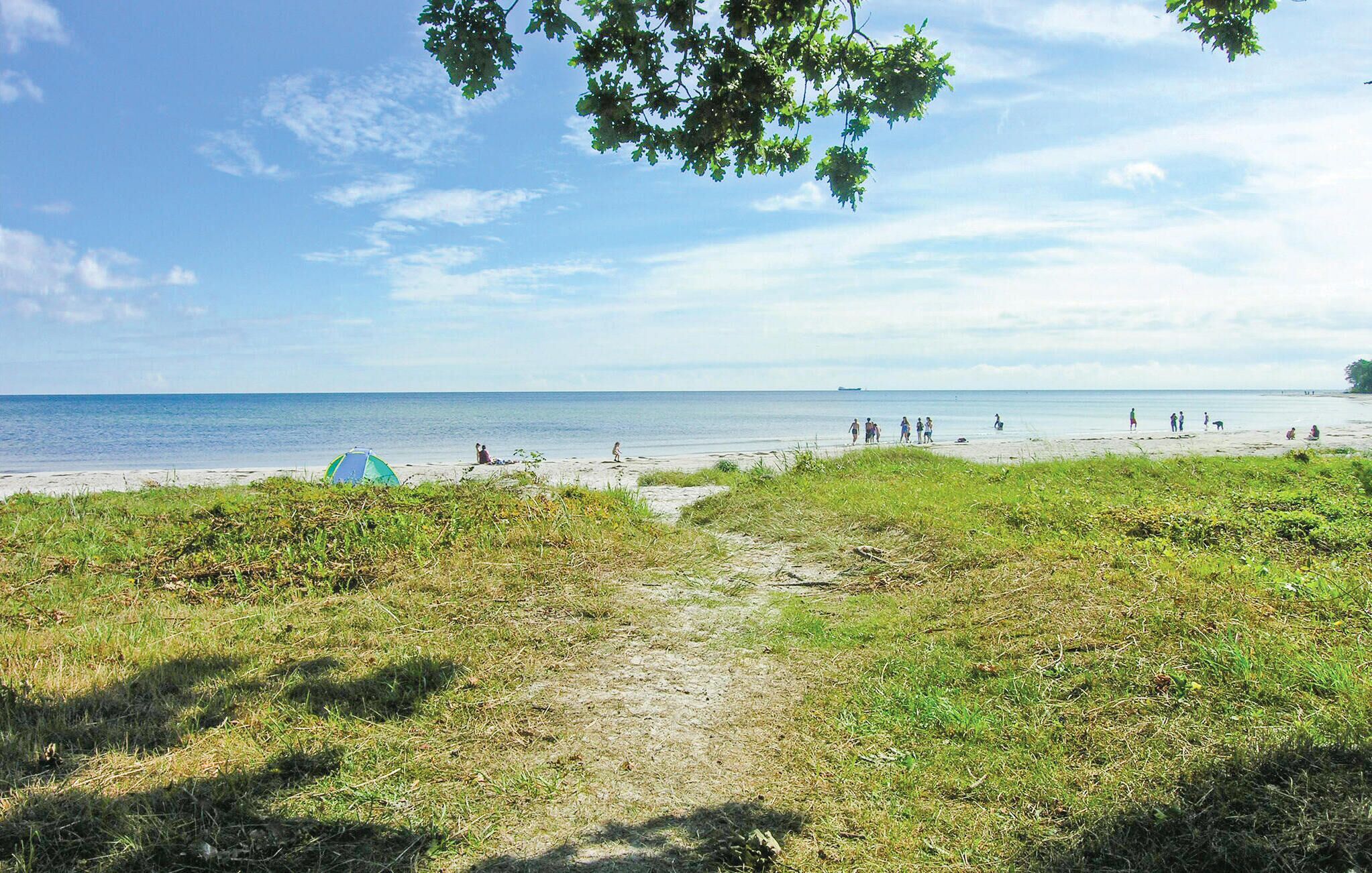 A beach with a tent and a path leading to the water.