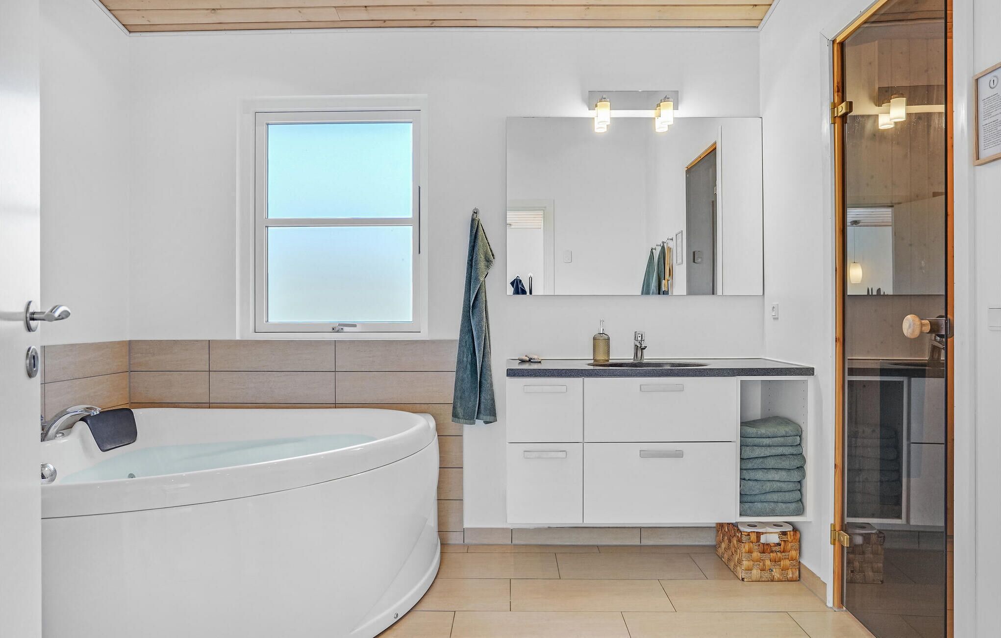 Un baño moderno con una bañera independiente, un tocador con espejo y una zona de ducha.