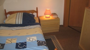 A bedroom with a bed, a bedside table with a lamp, and a nightstand. - 2 - - - floor 3 room (BC. A3) - BARLT - Ferienhaus Bärbel (Barlt)