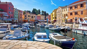 Um canal com barcos atracados, ladeado por edifícios coloridos.