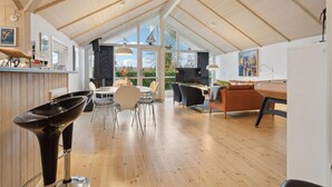 Un loft espacioso con techos altos, un comedor, una cocina con un ventanal grande y una zona de estar acogedora con chimenea.