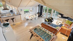 Un loft amplio con cocina, comedor y sala de estar, que incluye una mesa de fútbol y una chimenea.