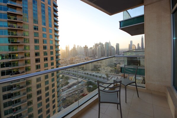 A balcony with a view of a cityscape, including high-rise buildings and a road.