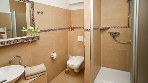 Een badkamer met een wastafel, toilet en douche.
