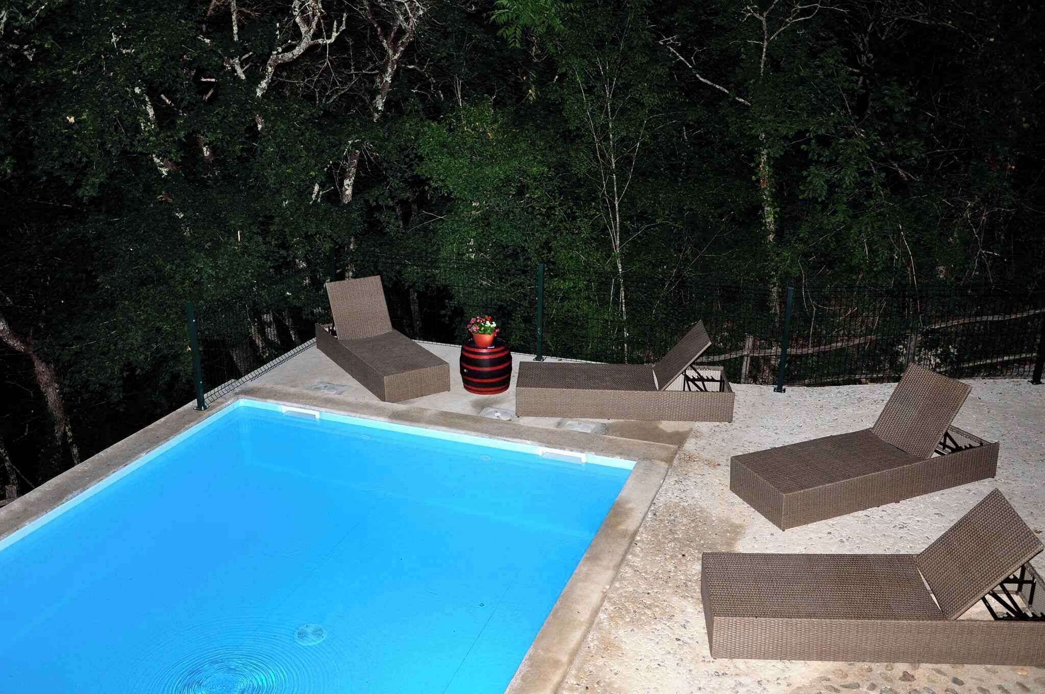 A rectangular pool with lounge chairs and a potted plant.