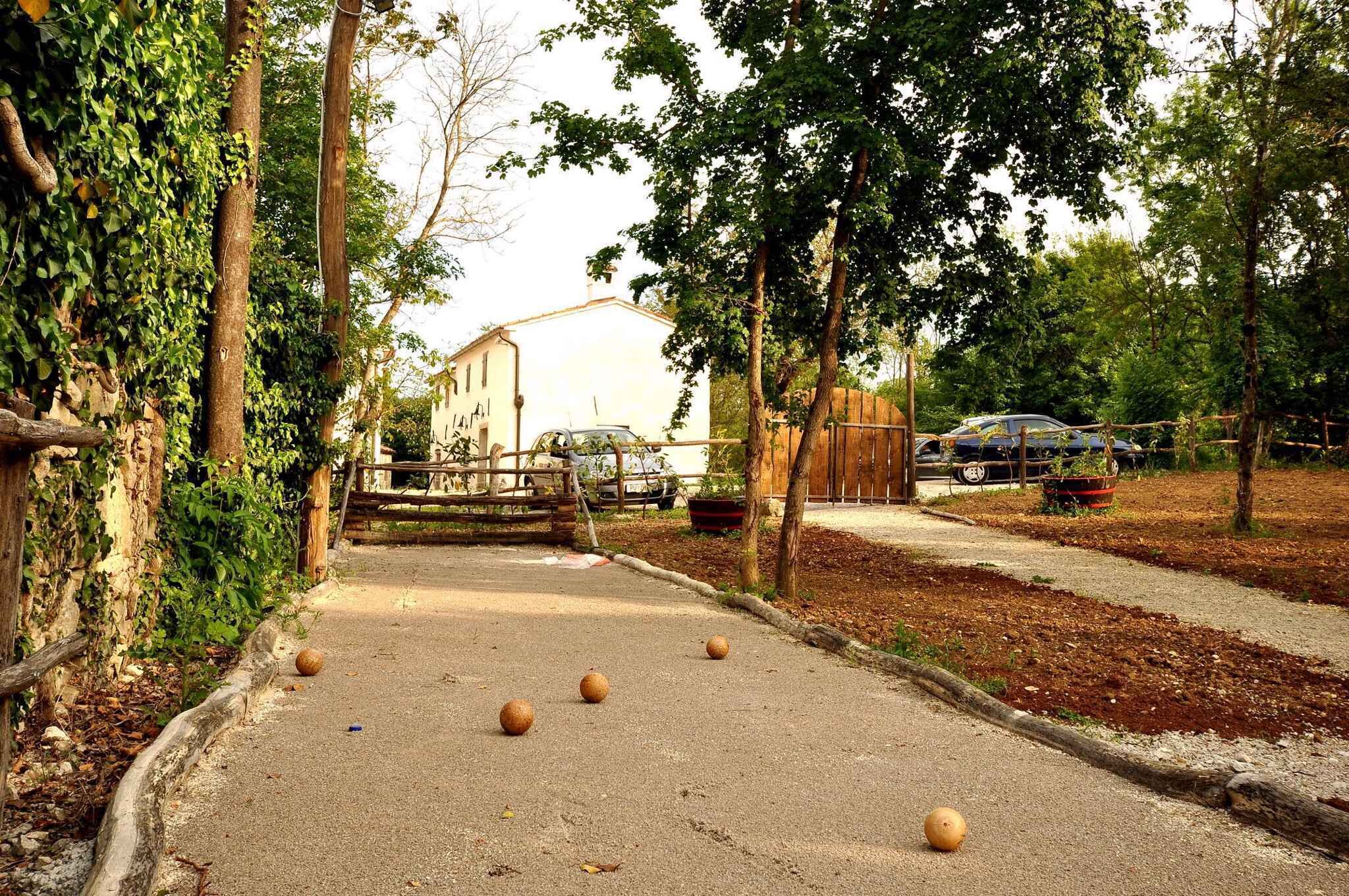 Un sendero pavimentado con pilares, rodeado de árboles y un edificio al fondo.