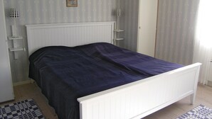 A bedroom with a white bed, a radiator, and a patterned rug on the floor. - 4 bedroom nice home in Bottnaryd (Bottnaryd)