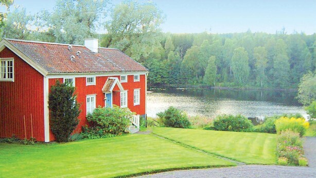 A red house with a sloped roof, a front porch, and a lawn in front. - 4 bedroom nice home in Bottnaryd (Bottnaryd)
