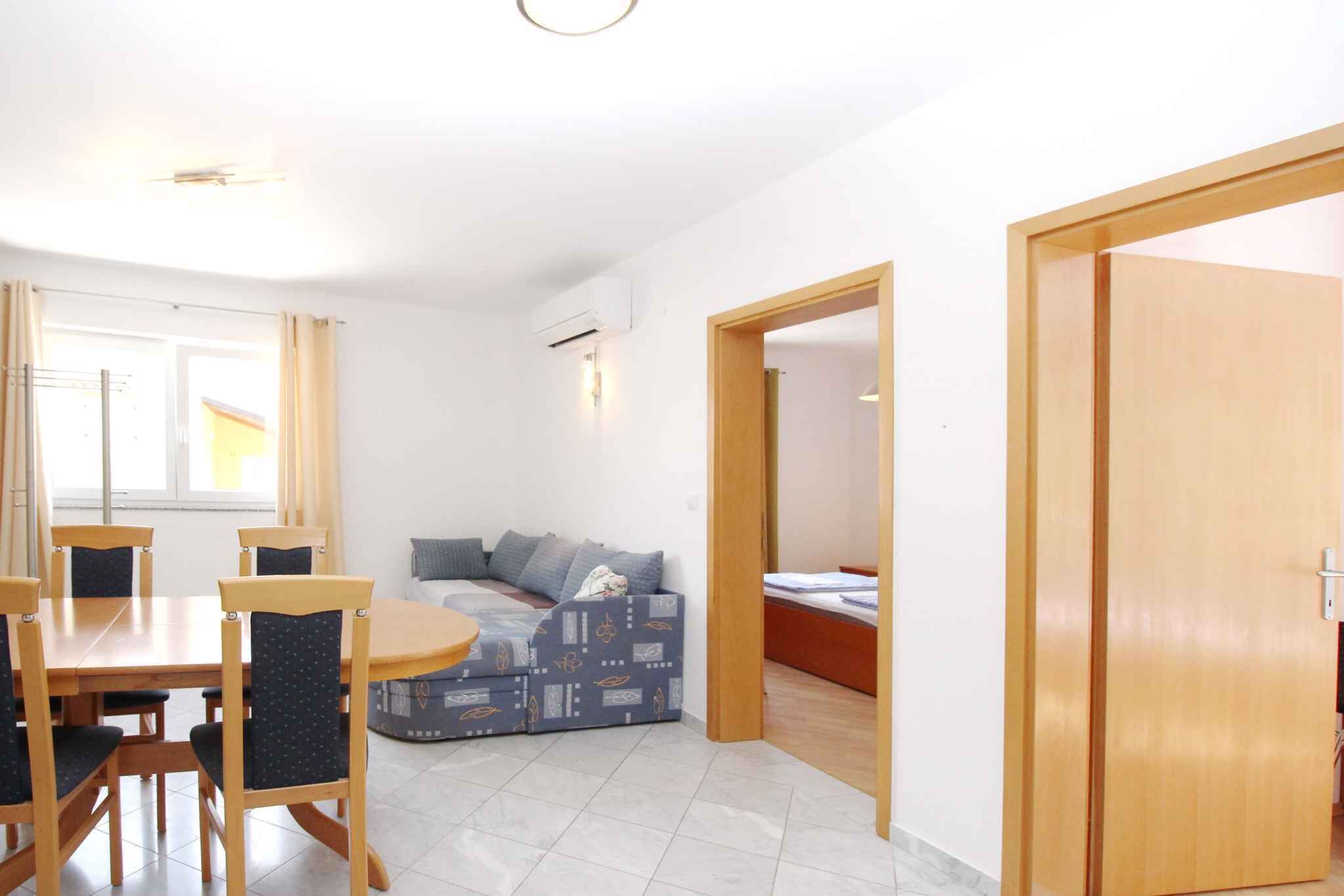A compact living space with a dining area, a sofa, and a bed.