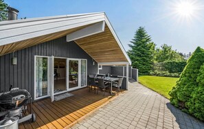 A modern house with a deck, a barbecue, and a patio with outdoor furniture. - Lovely home in Tarm with sauna (Tarm)