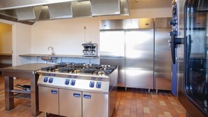 A commercial kitchen with stainless steel appliances, including a stove, refrigerator, and coffee machine. - Awesome home in Thyborøn with sauna (Thyborøn)