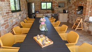 Una larga mesa de comedor con sillas amarillas, mantel negro y un centro de mesa con flores y figuras de erizos.