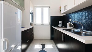 A modern kitchen with a refrigerator, oven, microwave, and a coffee maker. - Amazing apartment in Pag with house sea view (Pag)