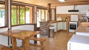 A kitchen with wooden countertops, a stone backsplash, and a gas stove. There is a trash can and a window with a view of greenery. - Cozy home in Eglise Neuve D'Issac (Eglise Neuve D'Issac)