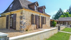 A stone building with a pitched roof, multiple windows with shutters, and a gravel driveway. - Cozy home in Eglise Neuve D'Issac (Eglise Neuve D'Issac)