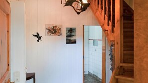 A hallway with a wooden staircase, a white door, and two wall-mounted bird sculptures. - Gorgeous apartment in Prerow with WiFi (Prerow)