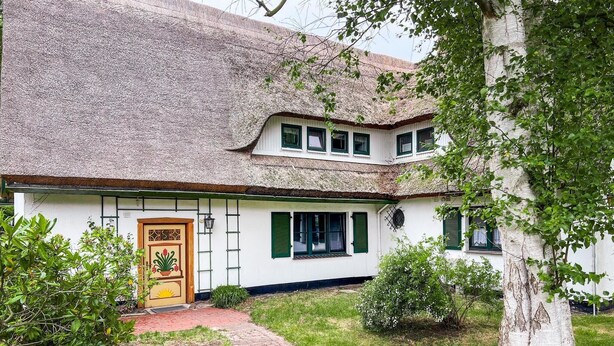 A traditional house with a thatched roof, white walls, and green shutters. - Gorgeous apartment in Prerow with WiFi (Prerow)