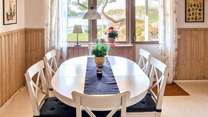 A dining area with a round table, white chairs, a black table runner, and a potted plant. - Stunning home in årjäng with WiFi (Årjäng)