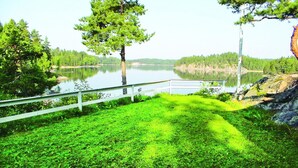 A lakeside view with a wooden deck and a metal railing. - Stunning home in årjäng with WiFi (Årjäng)