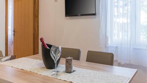 Un comedor con una mesa de madera, una copa de vino, una vela y una botella de champán.