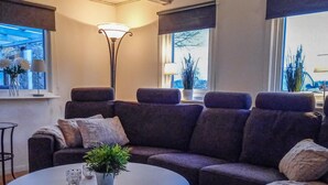 Un salon avec un canapé, une table basse et un lampadaire.