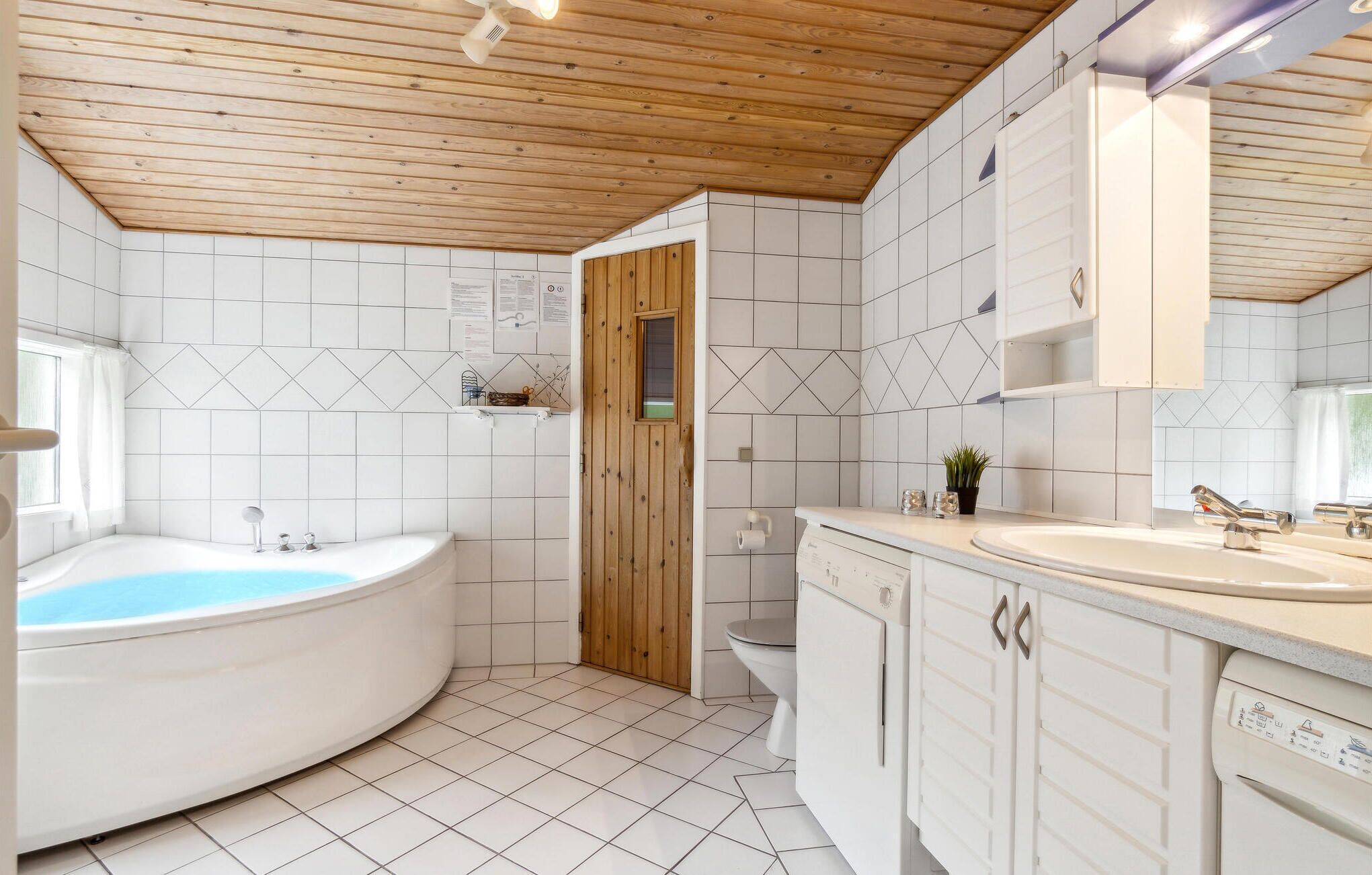 Een badkamer met een bad, toilet en wastafel.