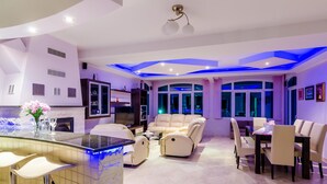 Una sala de estar moderna con un sofá, una mesa de comedor y una zona de cocina con barra integrada.