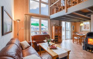 Ein gemütliches Wohnzimmer mit Ledersofa, Couchtisch aus Holz und Kamin.