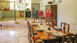 A dining area with a long wooden table set for a meal, surrounded by chairs. - Amazing home in Les Farges (Les Farges)