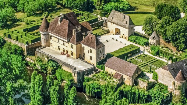 An aerial view of a historic castle with multiple buildings, a moat, and well-maintained gardens. - Amazing home in Les Farges (Les Farges)